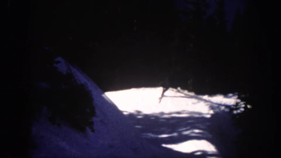 A distant skier glides across an artificially lit snow slope in Aspen, Colorado, in 1961 home-movie footage.