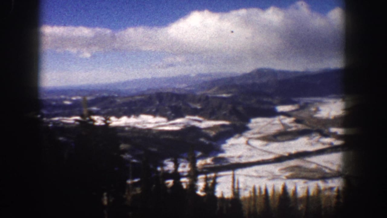 Aspen, Colorado 1961 home-movie view from a descending lift over a snowy valley and mountain ridges.