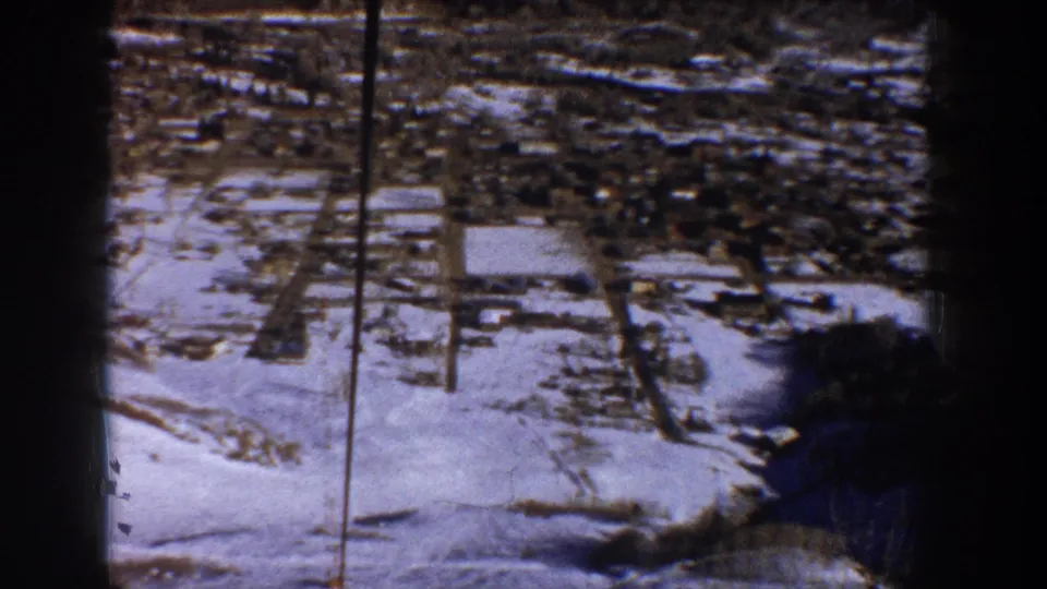 The frame shows a snow-covered town from above, likely Aspen, Colorado according to the clip metadata, with roads and buildings visible.
