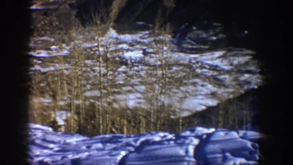1961 Aspen winter landscape with snow-covered ground, leafless trees, and shadowed hillside framed by a dark 8mm border.