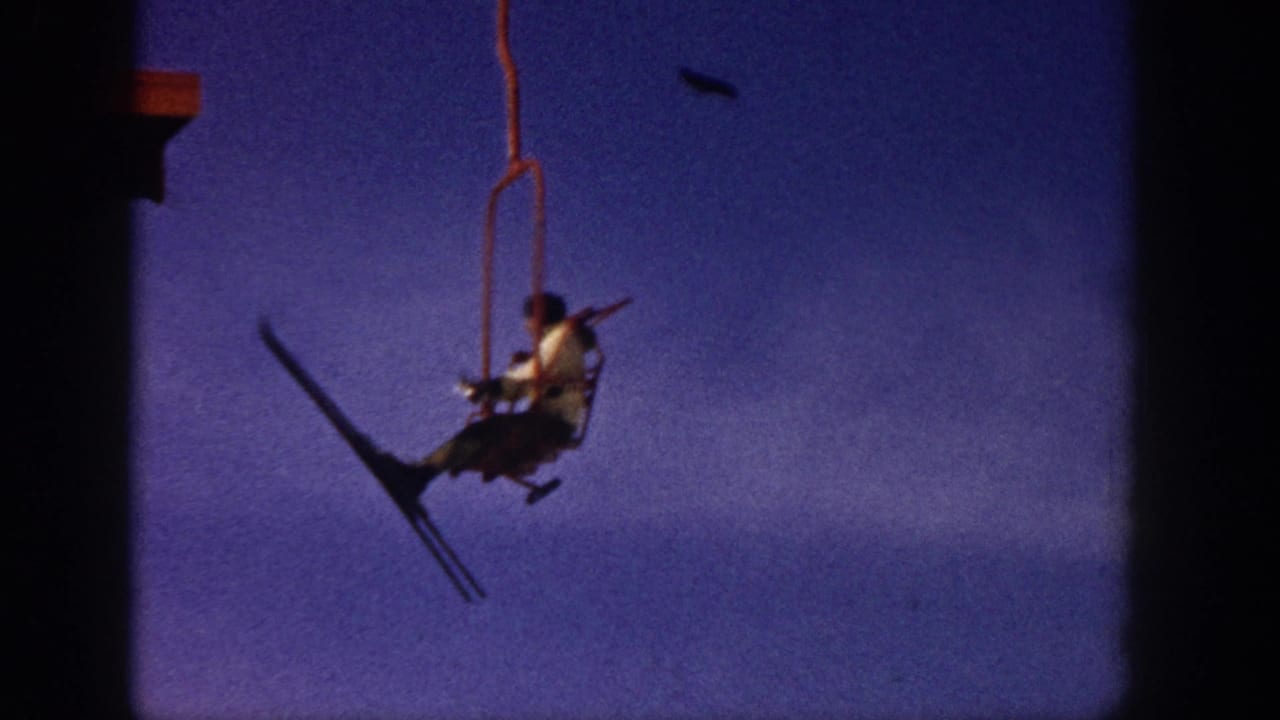 Chairlift rider appears farther right in frame with skis angled below the seat.