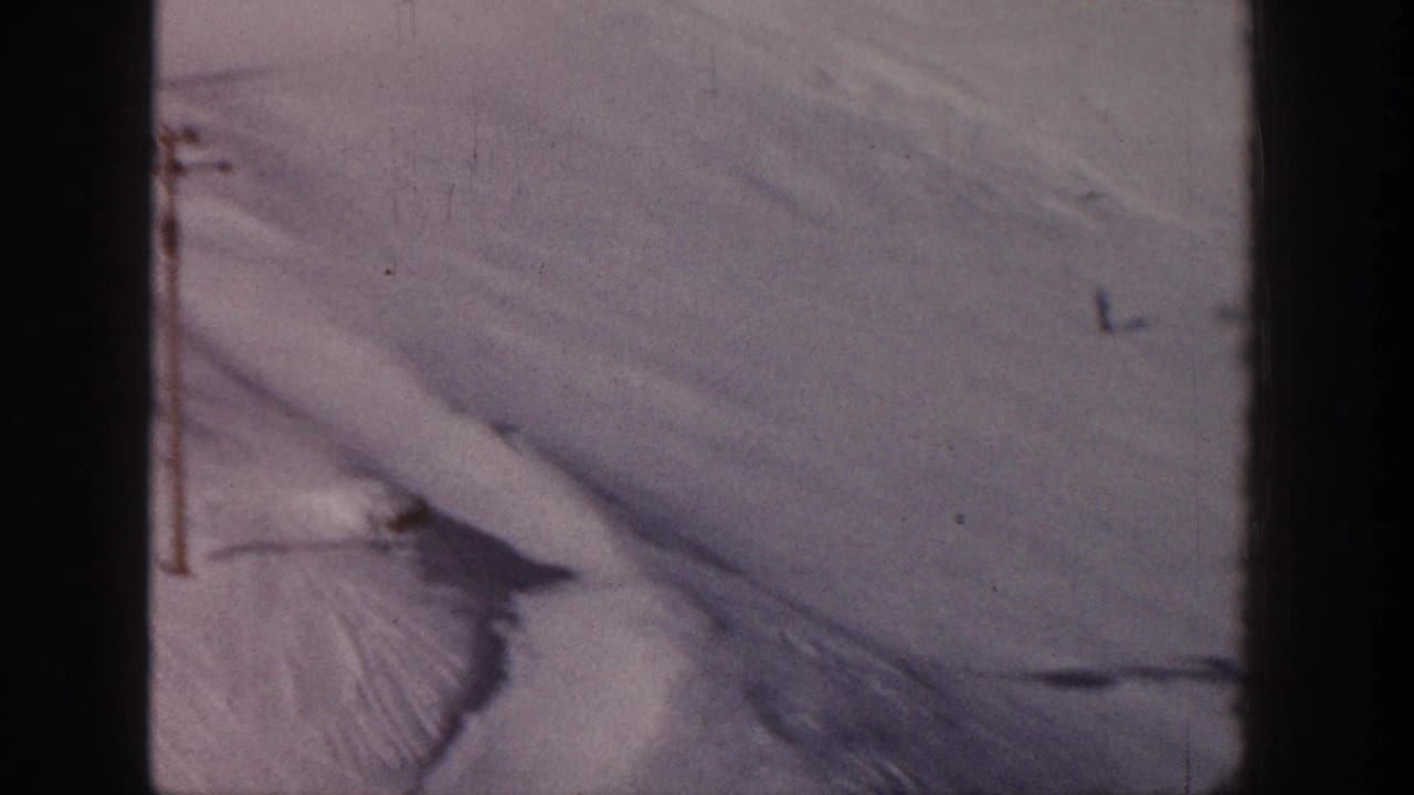 Snowy slope with lift pole and faint tracks across the terrain.