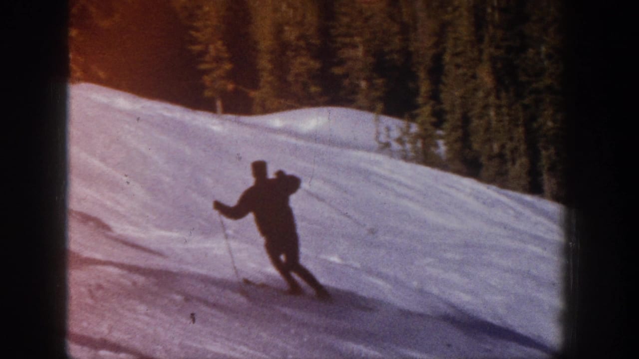 A distant skier in dark winter clothing descends a snowy Aspen slope in 1961 home-movie footage.