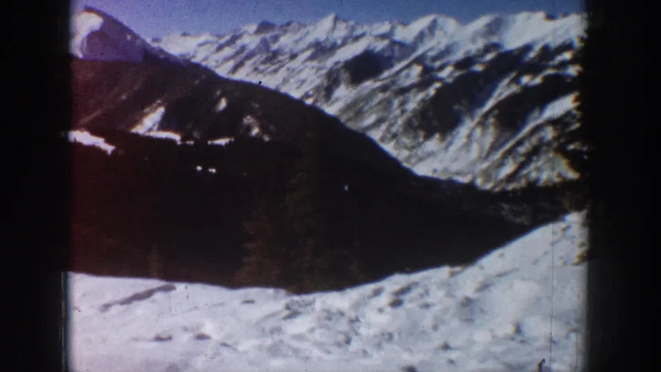 Aspen-area winter mountain view from the 1961 home movie, with snowy ridges and dark shadowed slopes.