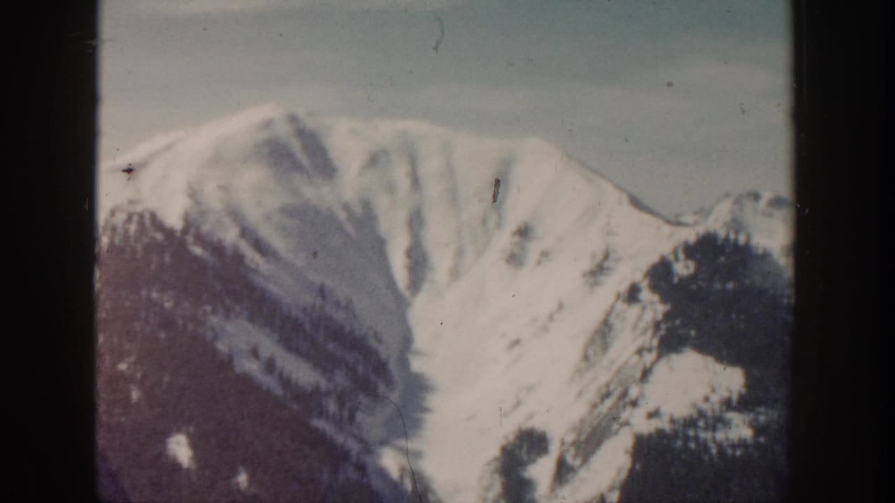 Snow-covered mountain face near Aspen, Colorado, seen through soft, faded 8mm home-movie framing.