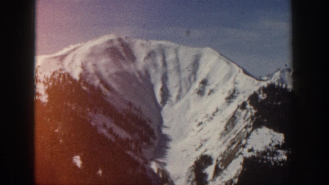 Snow-covered mountain peak near Aspen, Colorado, seen in 1961 8mm home-movie footage with soft focus and visible film edges.