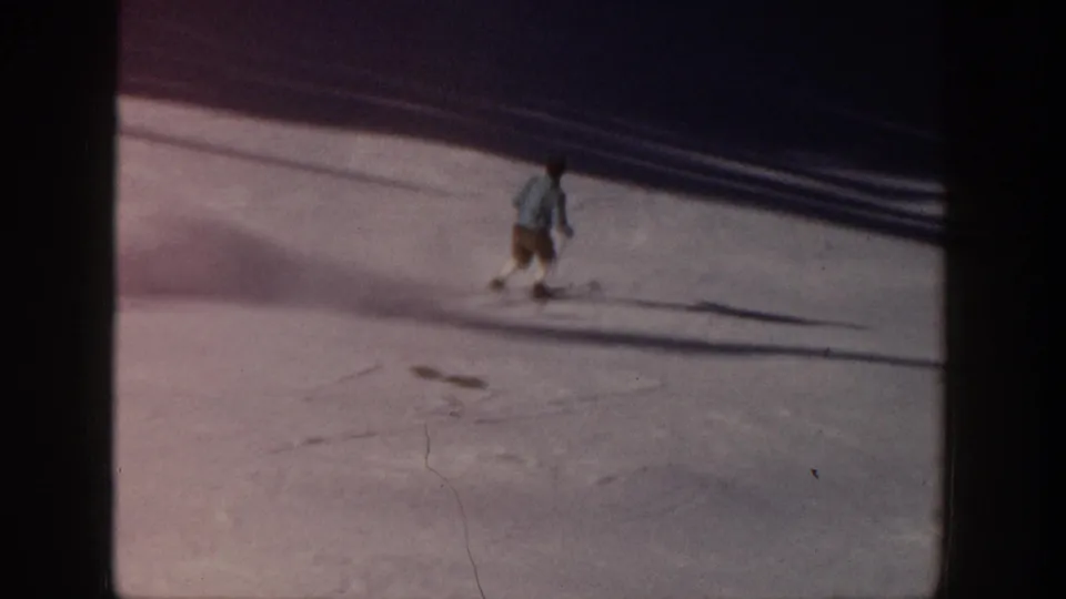 Distant skier on an Aspen snow slope in 1961, filmed from an elevated home-movie viewpoint with strong winter shadows.