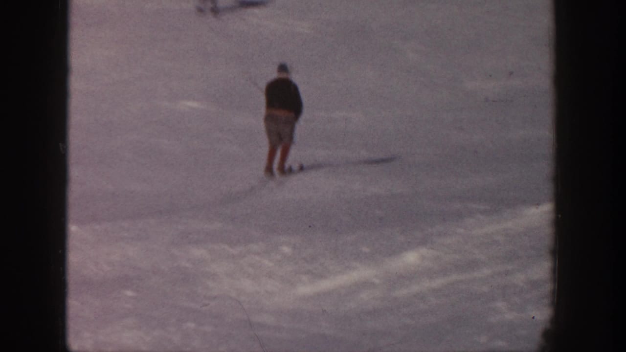 In 1961 Aspen, a lone skier appears near the upper left of a broad snow-covered slope, seen in soft 8mm color.