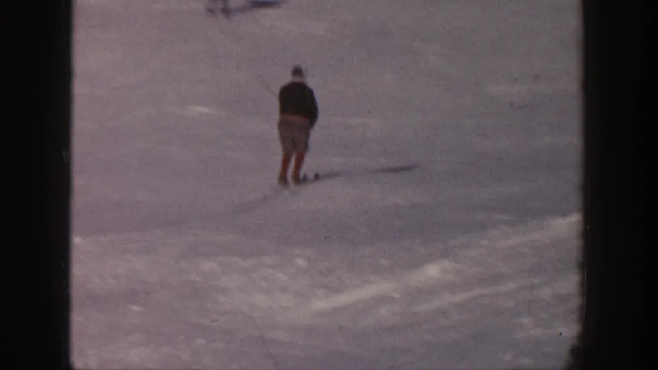 In 1961 Aspen, a lone skier appears near the upper left of a broad snow-covered slope, seen in soft 8mm color.