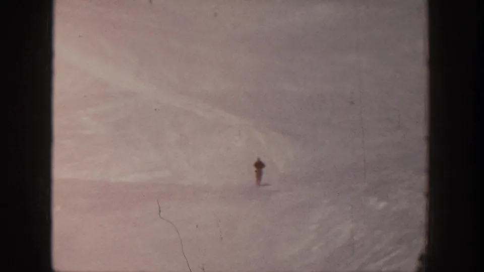 At the end of the 1961 Aspen home-movie shot, the skier remains distant against a broad, softly exposed snowy hillside.