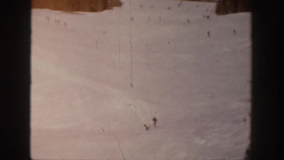 Wide 8mm view of an Aspen ski slope, with small figures visible against the snow near the top of the frame.