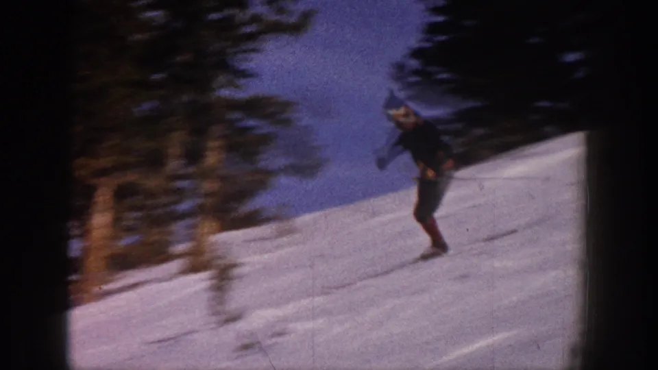 A man skis across a snowy Aspen, Colorado slope in 1961, framed by trees and dark 8mm contact-sheet borders.