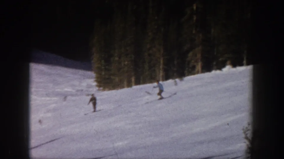 1961 Aspen skiing frame with two distant figures on a snow-covered hill, recorded in soft 8mm color.