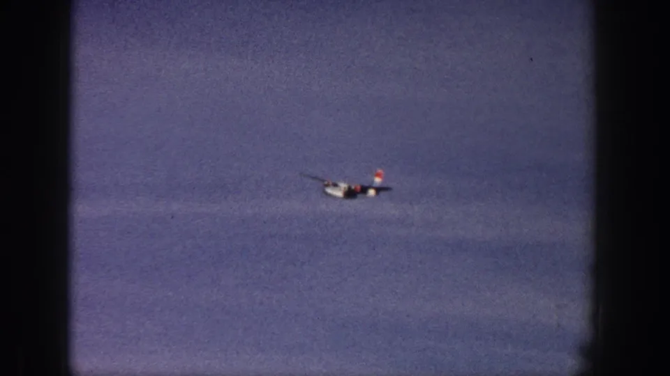 The small airplane remains visible in the cloudy sky near the end of the 1961 Aspen 8mm clip.