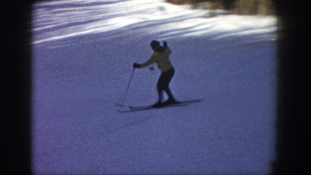 The skier traverses the snowfield, using poles while moving across the Aspen hillside in soft 8mm color.