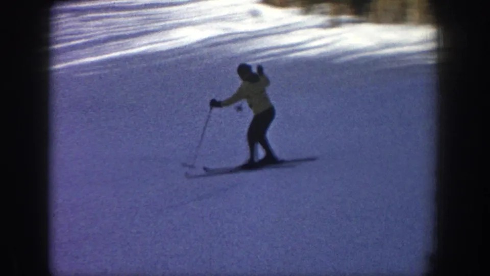 The skier traverses the snowfield, using poles while moving across the Aspen hillside in soft 8mm color.