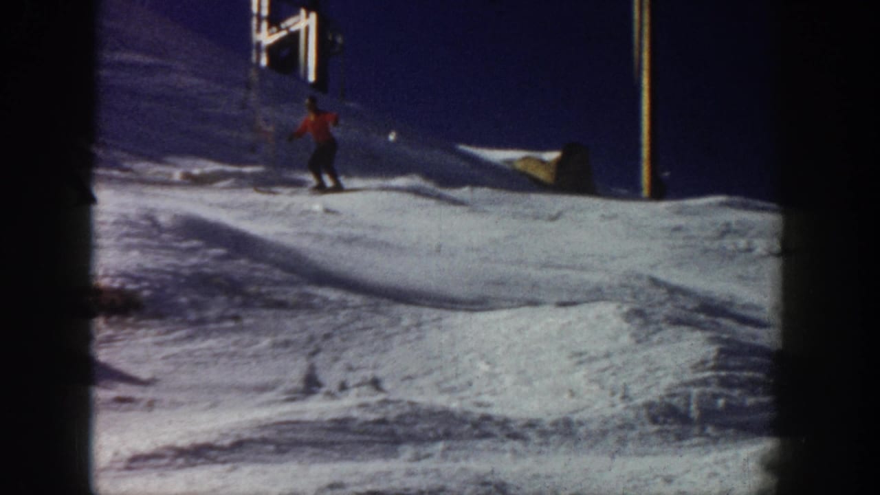 Aspen, Colorado 1961 frame of a skier in red descending a snow-covered slope with a ski lift structure visible above.