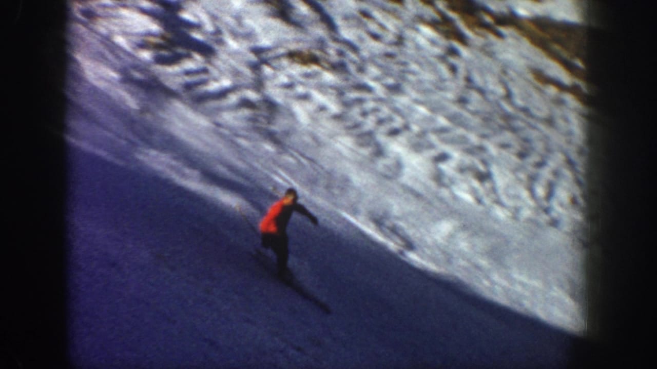 In metadata-supported 1961 Aspen, a distant skier in red moves across a shaded snow slope beneath a bright ridge.