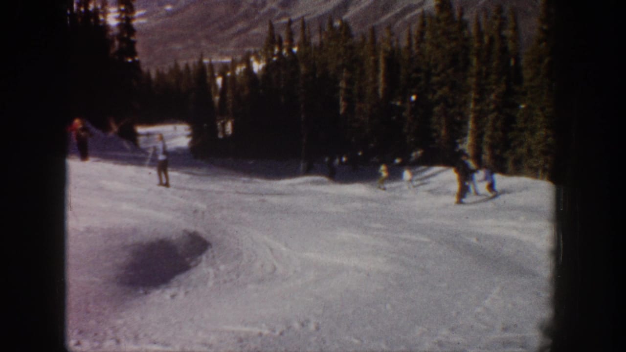 Dimmer 1961 Aspen ski frame with skiers near the right edge, a tree-lined slope, and visible 8mm film borders.