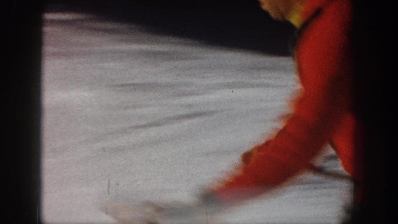 A motion-blurred close pass shows the red-sweater skier crossing the frame over snow in the Aspen 8mm footage.