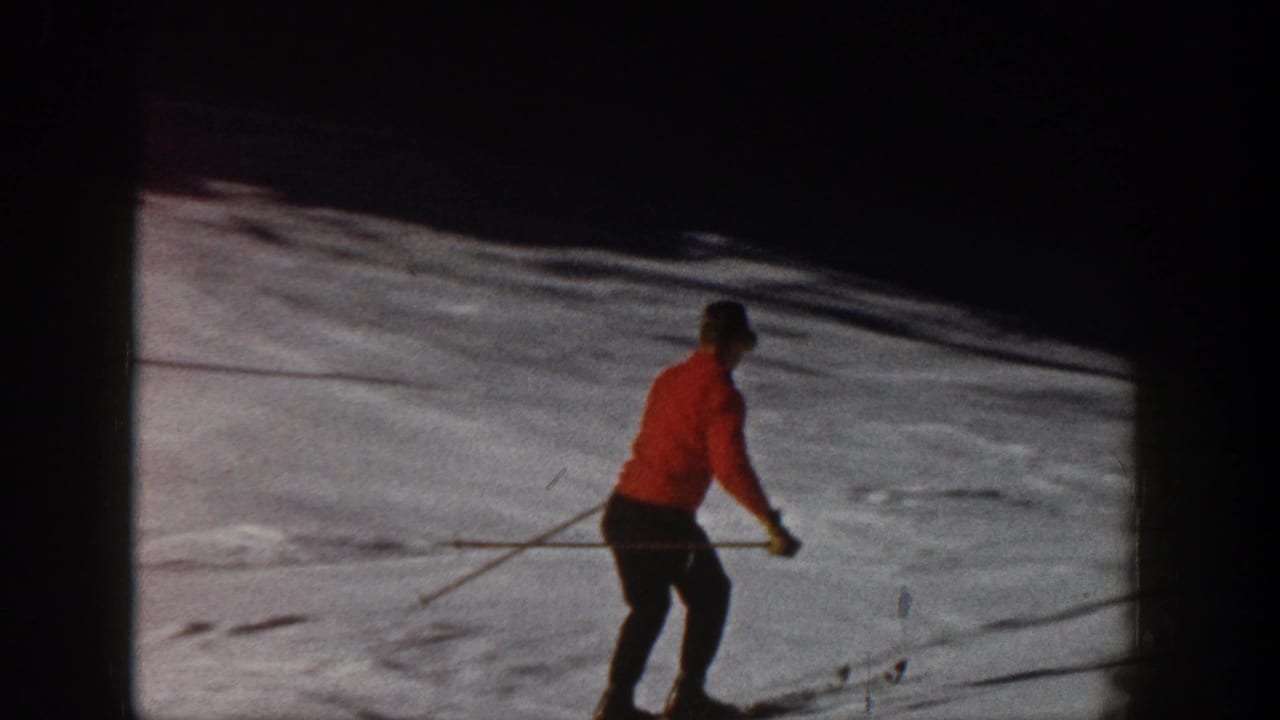 Skier in red moves across a snow-covered slope.