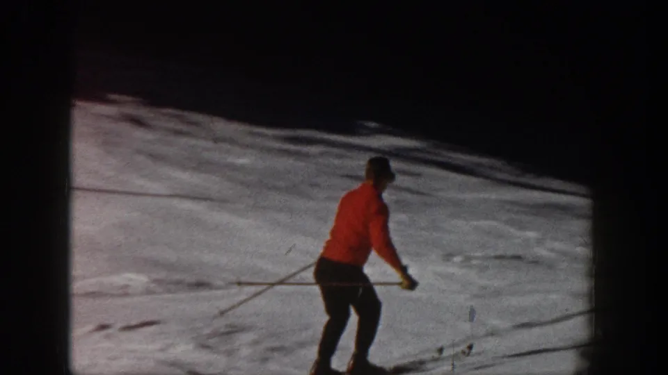 Aspen, Colorado 1961 footage shows the red-jacketed skier traversing a bright snowy hillside.