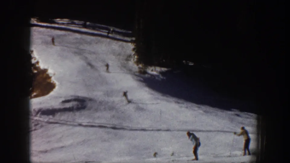 1961 Aspen ski slope view with multiple skiers spread across the snow and two figures near the right edge.