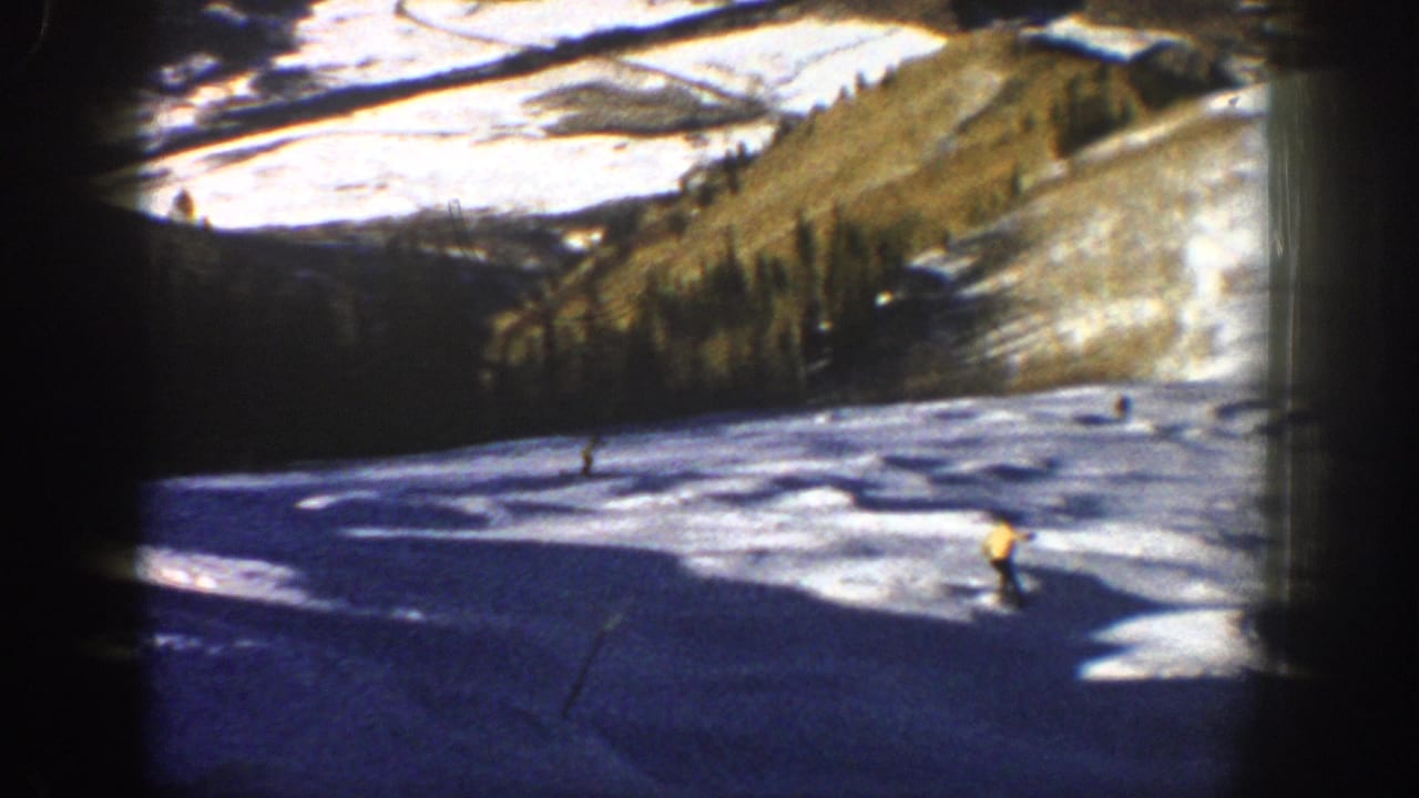 Aspen, Colorado ski footage from 1961 showing a yellow-jacketed skier near the foreground with other skiers farther uphill.