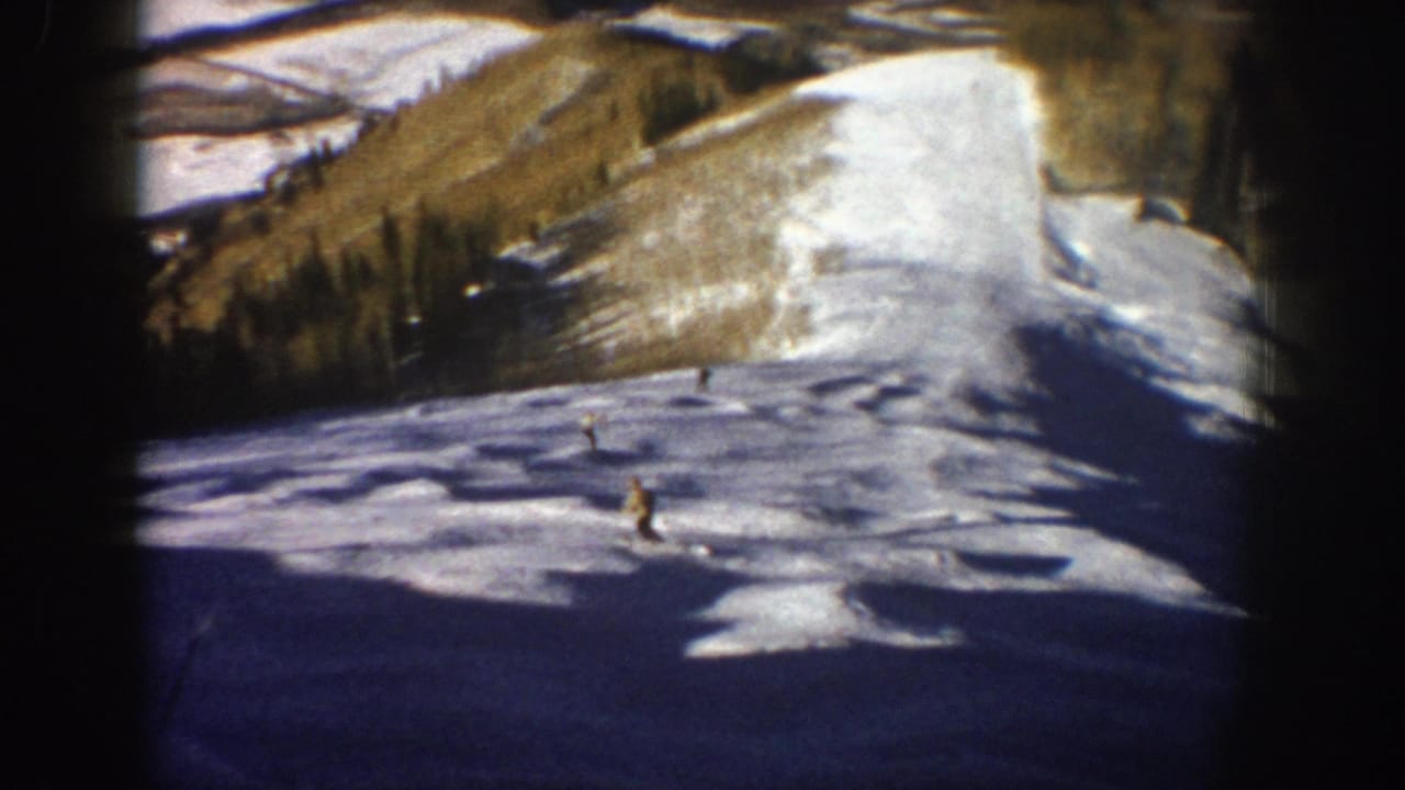 1961 Aspen ski scene with multiple distant skiers on an open slope, bordered by pines and visible 8mm film vignetting.
