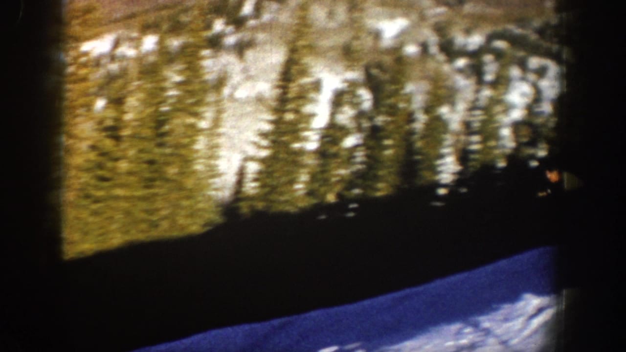 Aspen winter landscape on 8mm film, with snow, trees, and dark frame edges from the scan.