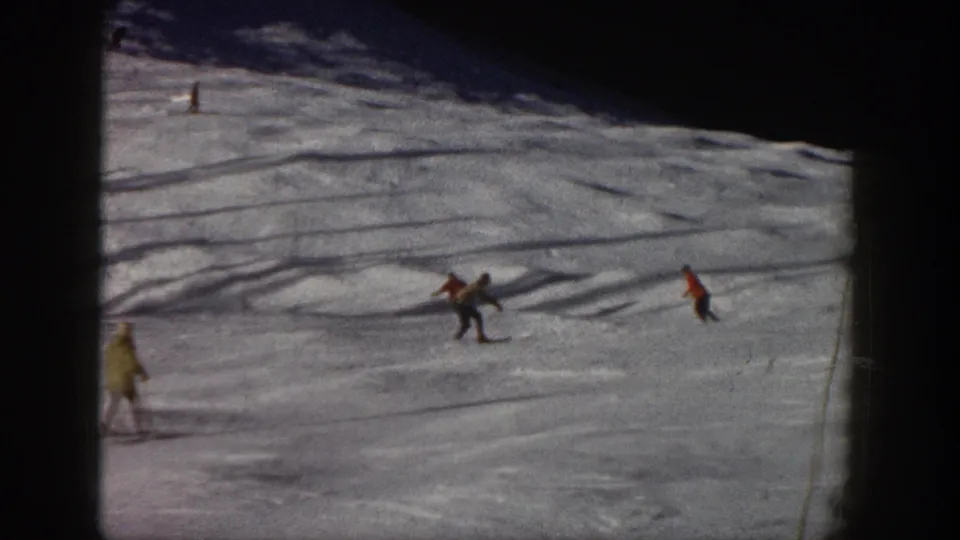 Distant skiers on an Aspen snow slope in 1961, with one central pair and others spaced across the run.