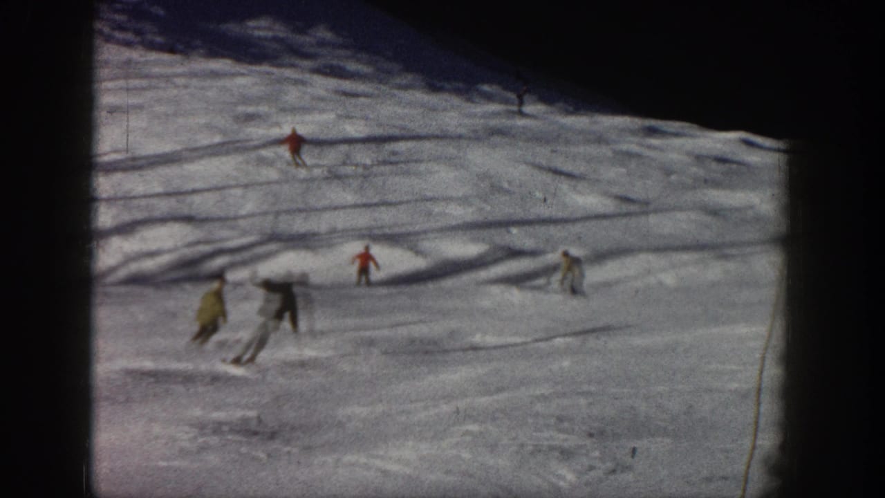 Aspen, Colorado skiing scene from 1961 showing distant figures in winter clothing crossing a snowy run.