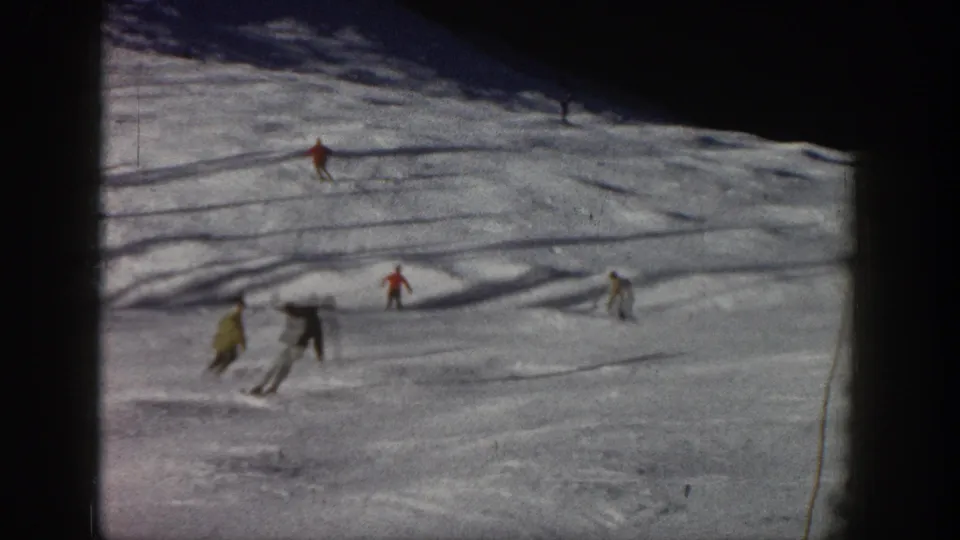 Aspen, Colorado skiing scene from 1961 showing distant figures in winter clothing crossing a snowy run.