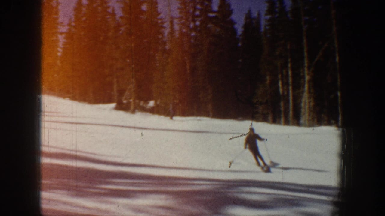 1961 Aspen ski scene showing a skier on a snowy run beside evergreens, with warm color shift and visible film edge.