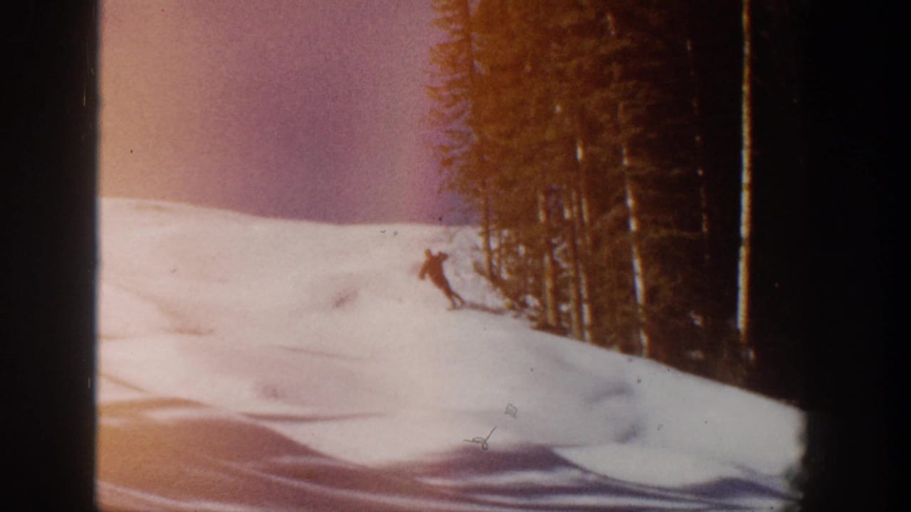 1961 Aspen 8mm frame with a skier descending near tall evergreens and warm film color shift.