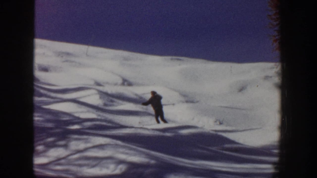 1961 Aspen footage shows the skier farther down the snowy slope, framed by shadow patterns and visible film borders.