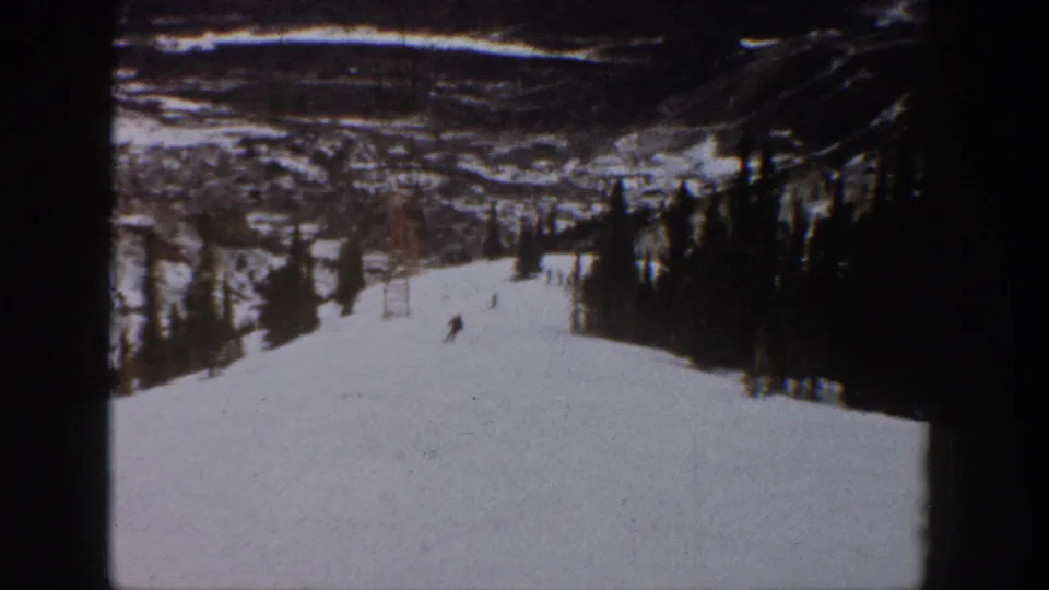The final frame holds a distant skier on the Aspen snow slope, with evergreen trees and mountain contours in faded 8mm color.