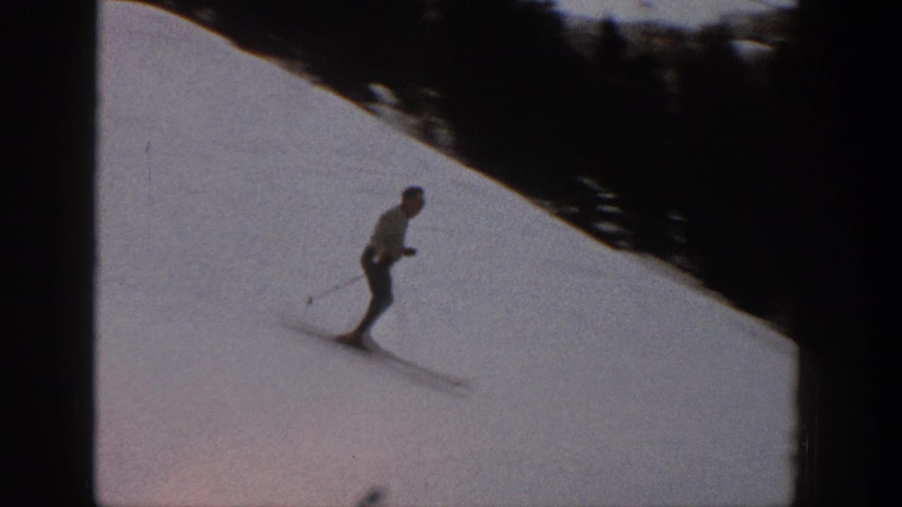 In 1961 Aspen, Colorado, a distant skier moves across a snowy mountain slope with dark trees or shadow along the upper edge.