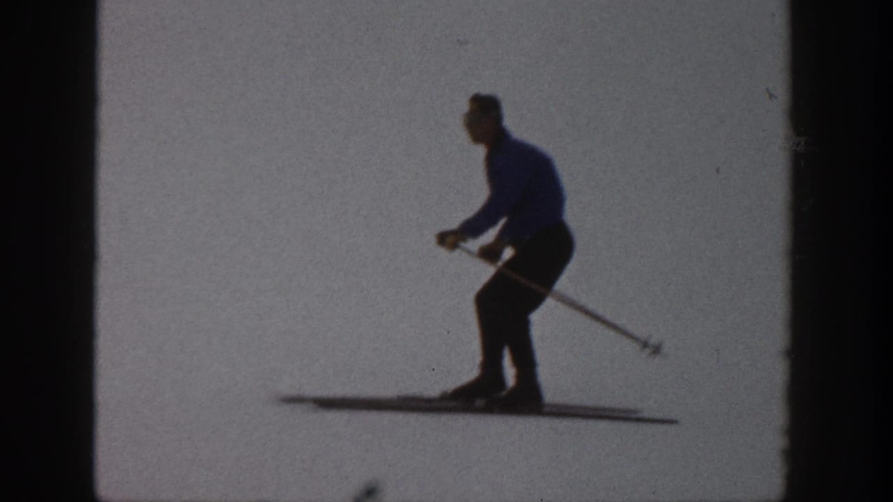 Skier continues across the snow, leaning forward with poles trailing behind.