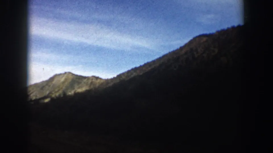 Aspen, Colorado 8mm travel view with a bright mountain peak, shadowed ridge, blue sky, and heavy dark edge framing.