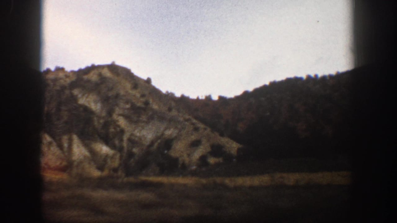 1961 Aspen-area mountain hillside and dry valley viewed from inside a moving car on 8mm film.