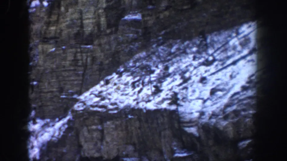 1961 Aspen, Colorado mountain detail showing snow on rugged rock, with the road mostly out of view.