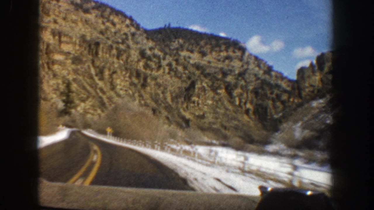 1961 Aspen-area home-movie view from inside a vehicle on a snowy two-lane mountain highway.