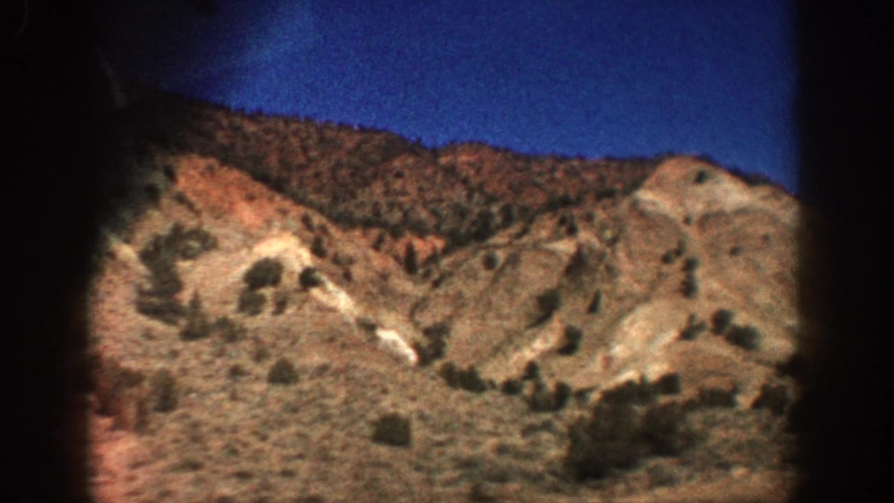 1961 Aspen-area 8mm frame showing arid rolling hills and sparse vegetation through a dark-edged home-movie view.