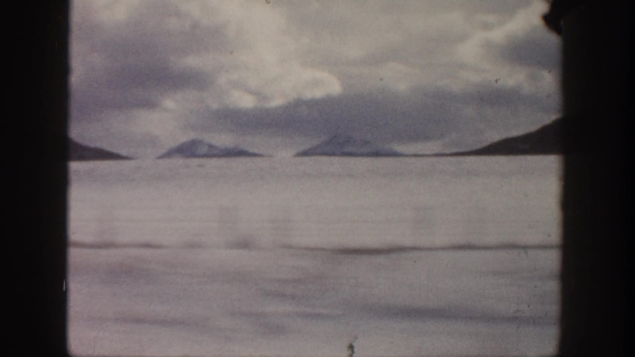 Aspen, Colorado 1961 8mm frame showing distant mountain forms beneath a cloudy sky, partially obscured by dark film borders.