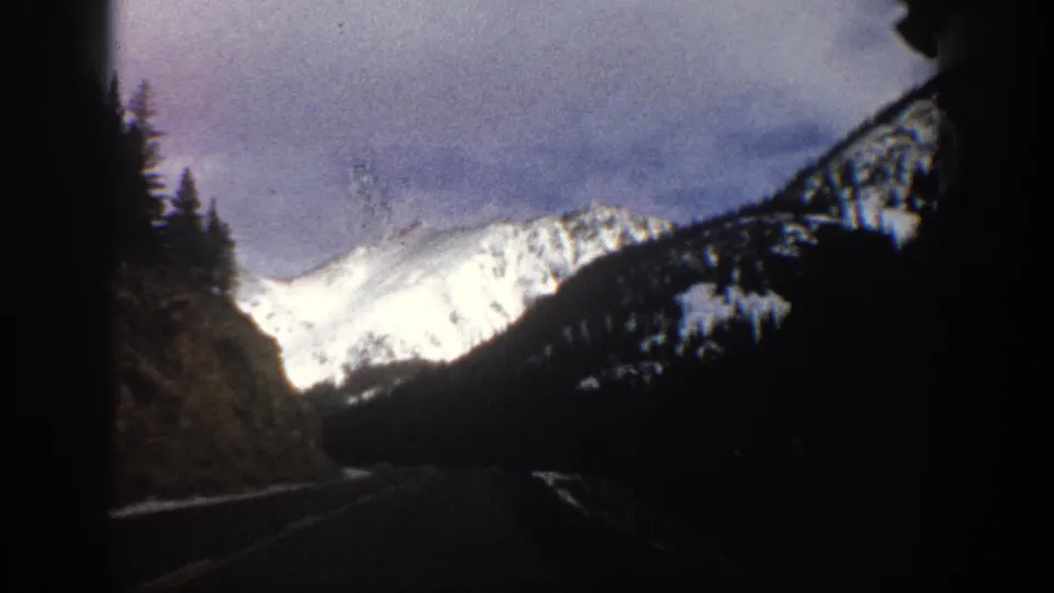 Final frame shows the winter road continuing toward snow-covered mountain slopes near Aspen, Colorado, in 1961 8mm footage.