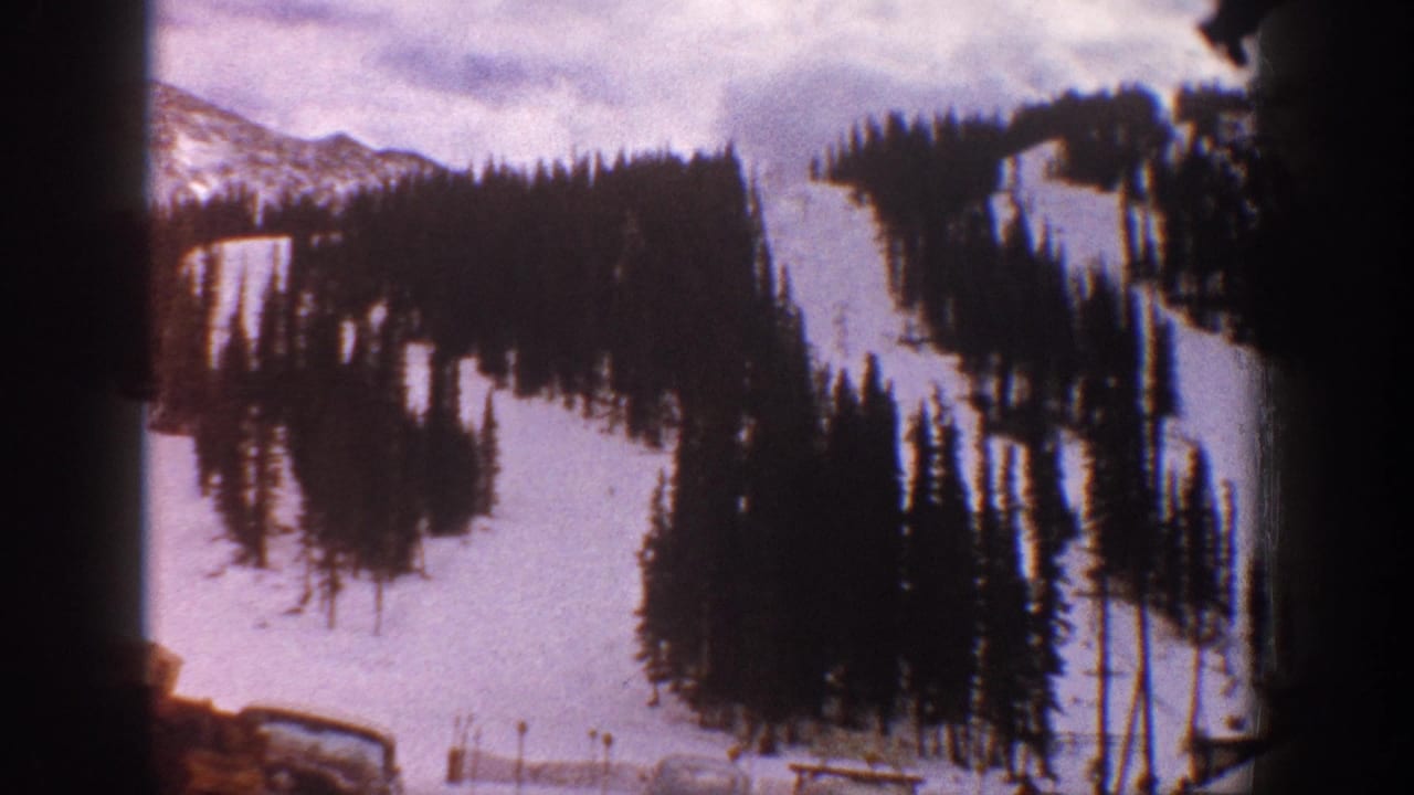 Aspen resort slope in 1961, with snowfields, evergreen stands, lift-area details, and a dark film-frame border.