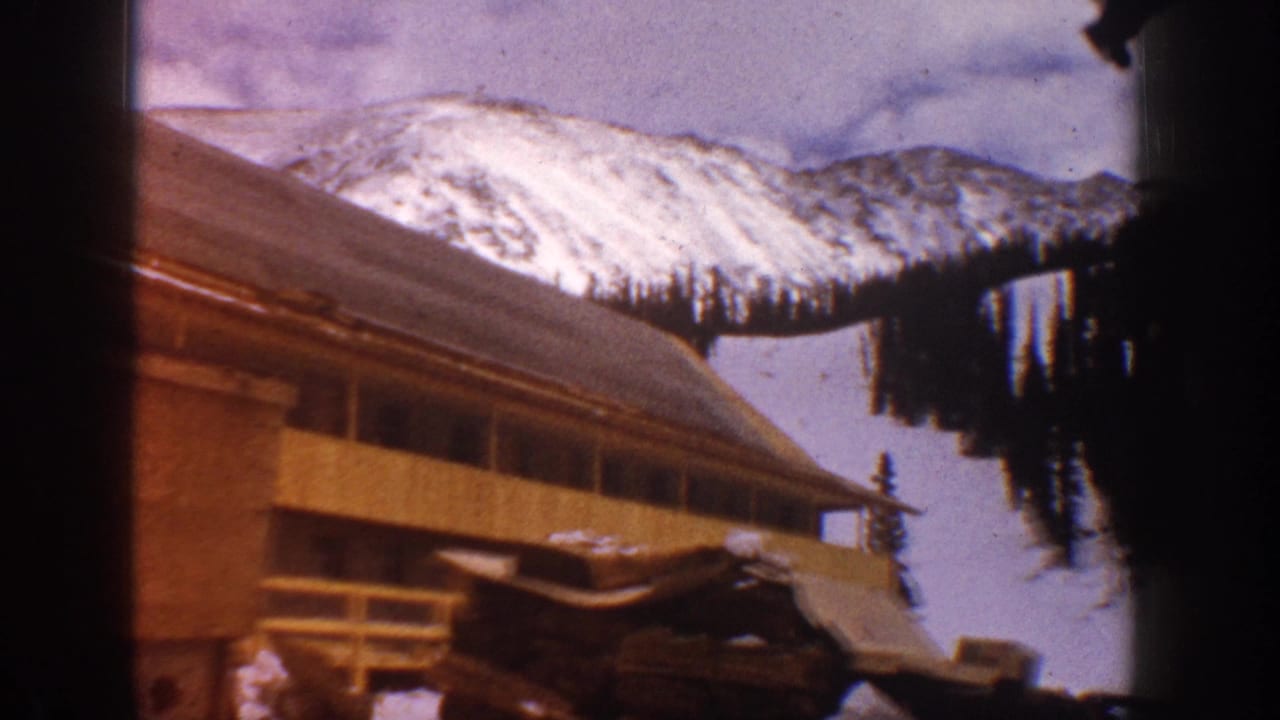 Aspen, Colorado travel footage frame with a wood-sided building in front of snowy slopes and distant mountain ridges.