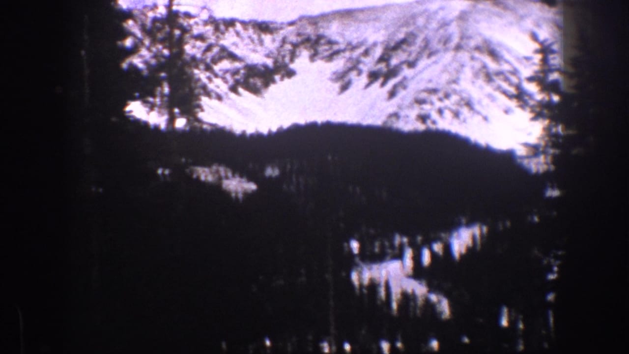 Aspen-area mountain landscape with snowfields, evergreen silhouettes, and visible 8mm gate-edge artifacts.