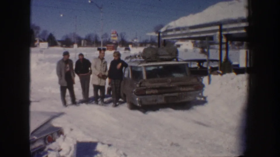 In Aspen, Colorado in 1961, four adults stand in deep snow beside a loaded station wagon during a winter farewell.